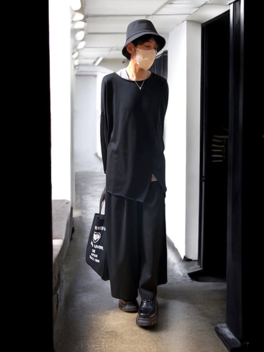 「やっぱり帽子が好き、レイヤードスタイル、ワイドパンツ、ハカマパンツ、革靴、バケットハット、トートバッグ、チャイハネ、モード、オールブラック、切り替えシャツ」｜「チャイハネのアイテム（Tシャツ/カットソー、ブラック系）」を使った、しーお さん（メンズ・180cm）の春コーディネートの2枚目の写真