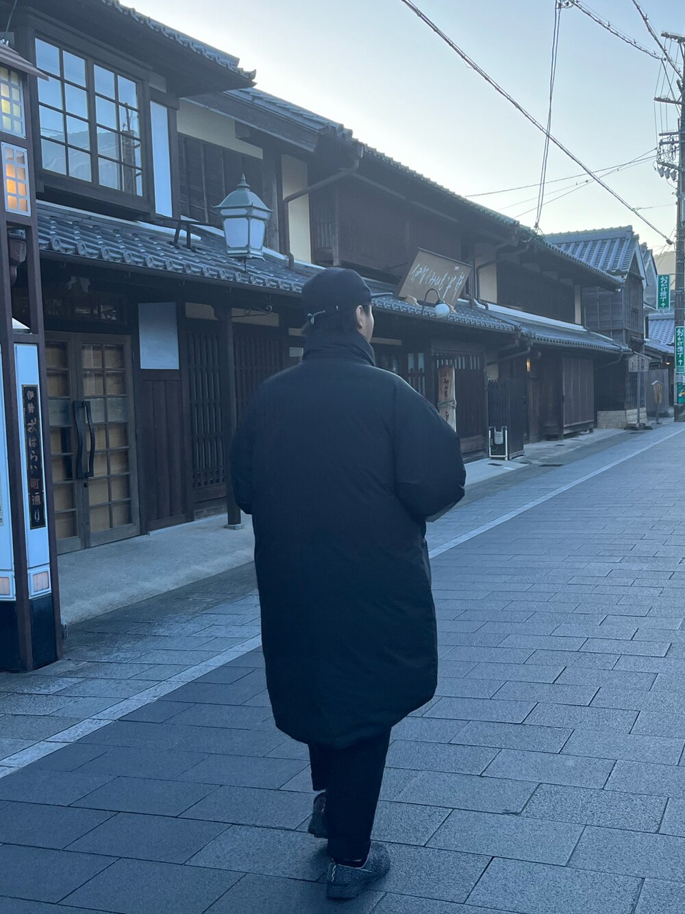 ブラック系のダウンジャケット/コート、ブルー系のスニーカー、ブラック系のチノパンツを着用したメンズの冬コーディネートの2枚目の写真