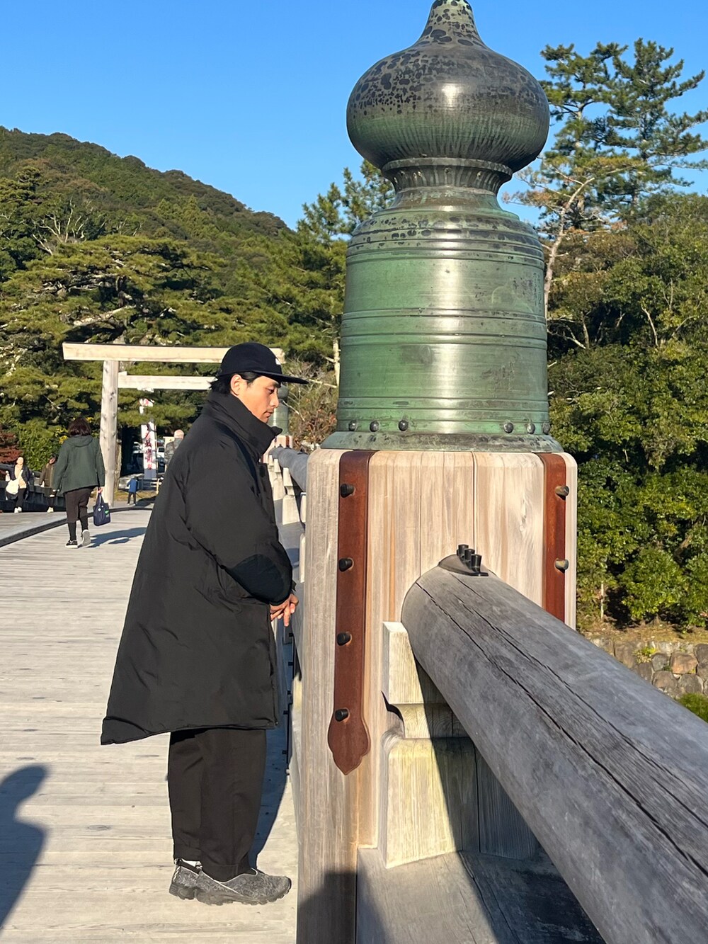 ブラック系のダウンジャケット/コート、ブルー系のスニーカー、ブラック系のチノパンツを着用したメンズの冬コーディネートの3枚目の写真