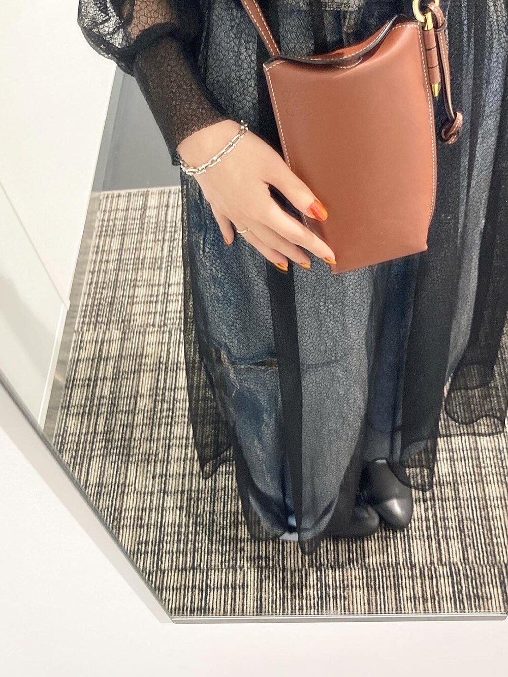 ブラック系のベスト、ブラック系のドレス、ブルー系のデニムパンツを着用したレディースの冬コーディネートの3枚目の写真