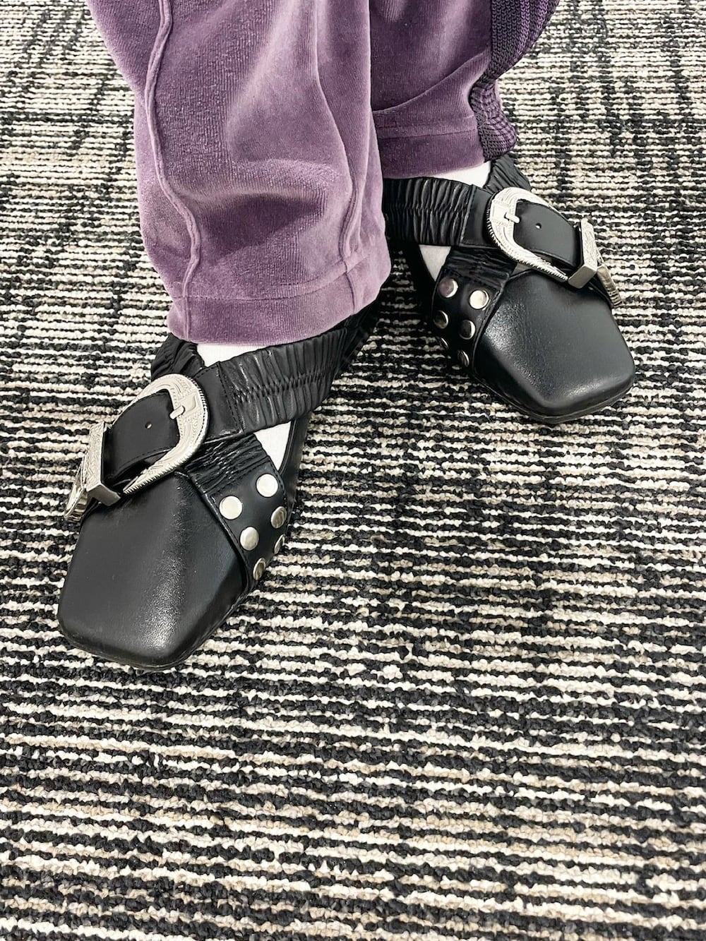 パープル系のパンツ、ブラック系のシューズ、ブラック系のショルダーバッグを着用したレディースの冬コーディネートの4枚目の写真