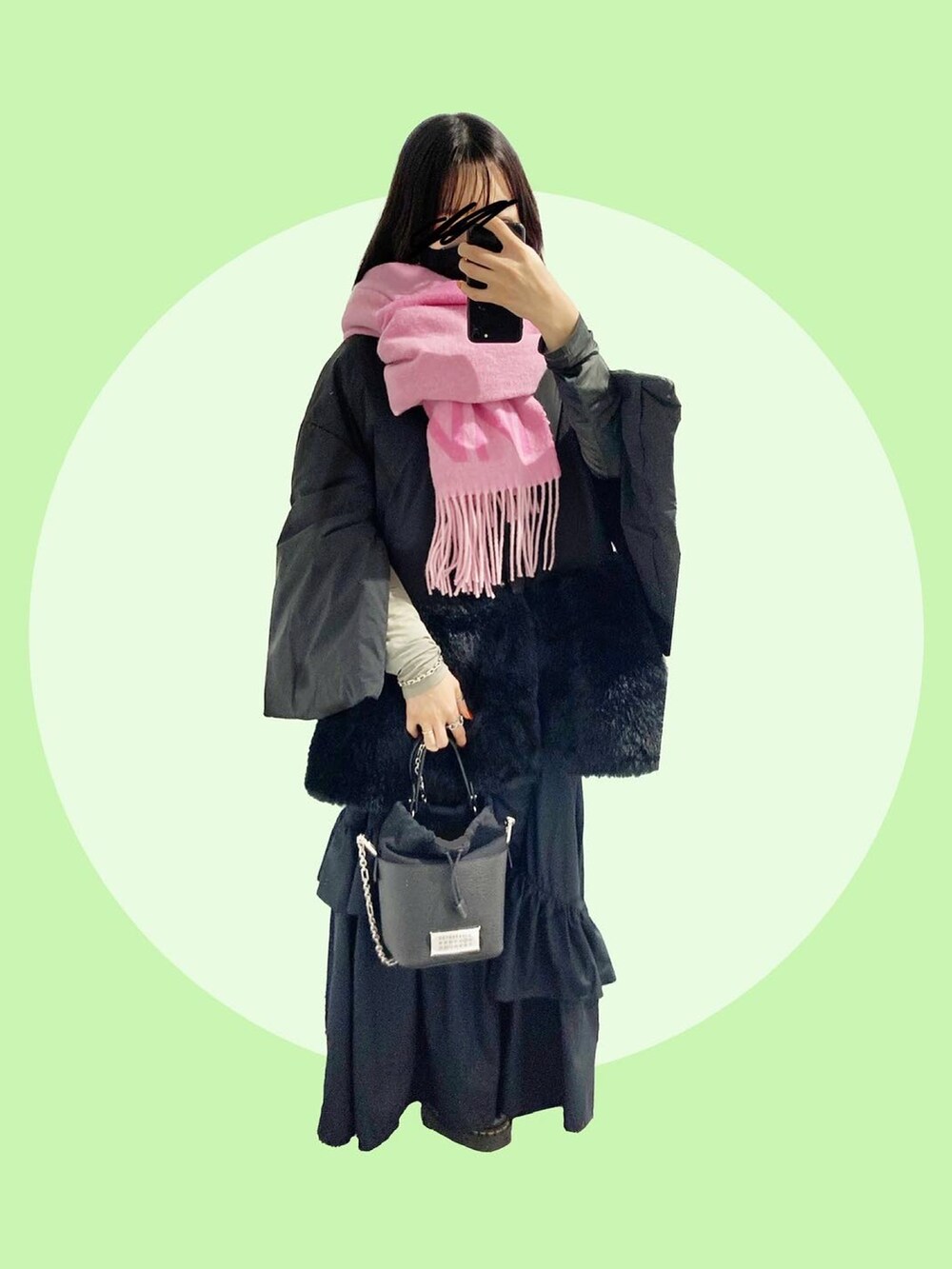 ブラック系のショルダーバッグ、ブラック系のスカート、ブラック系のブーツを着用したレディースの冬コーディネートの3枚目の写真