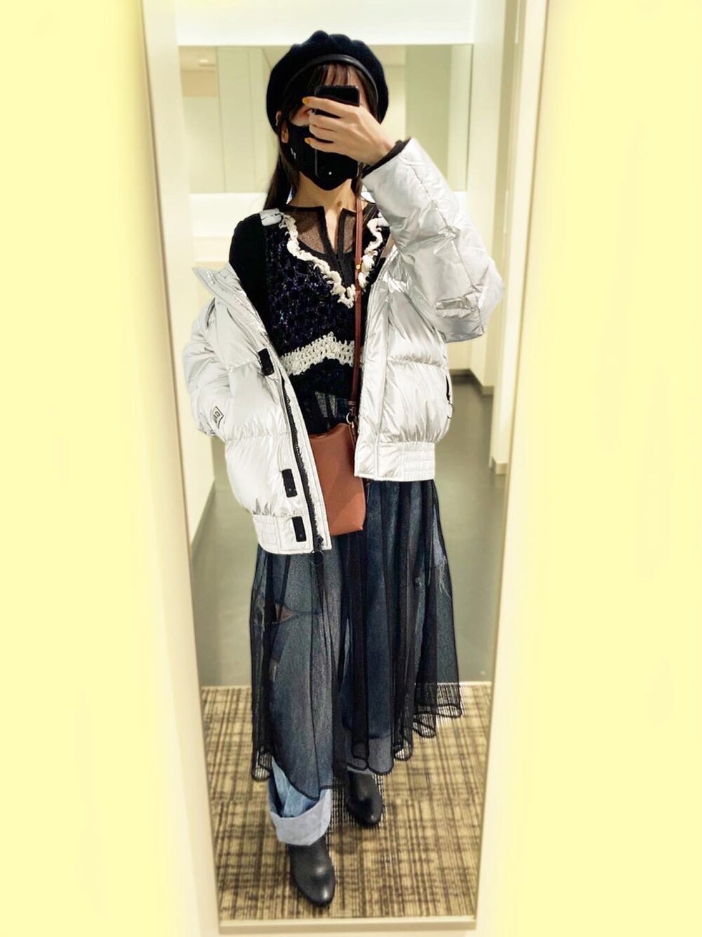 ブラック系のベスト、ブラック系のドレス、ブルー系のデニムパンツを着用したレディースの冬コーディネートの2枚目の写真