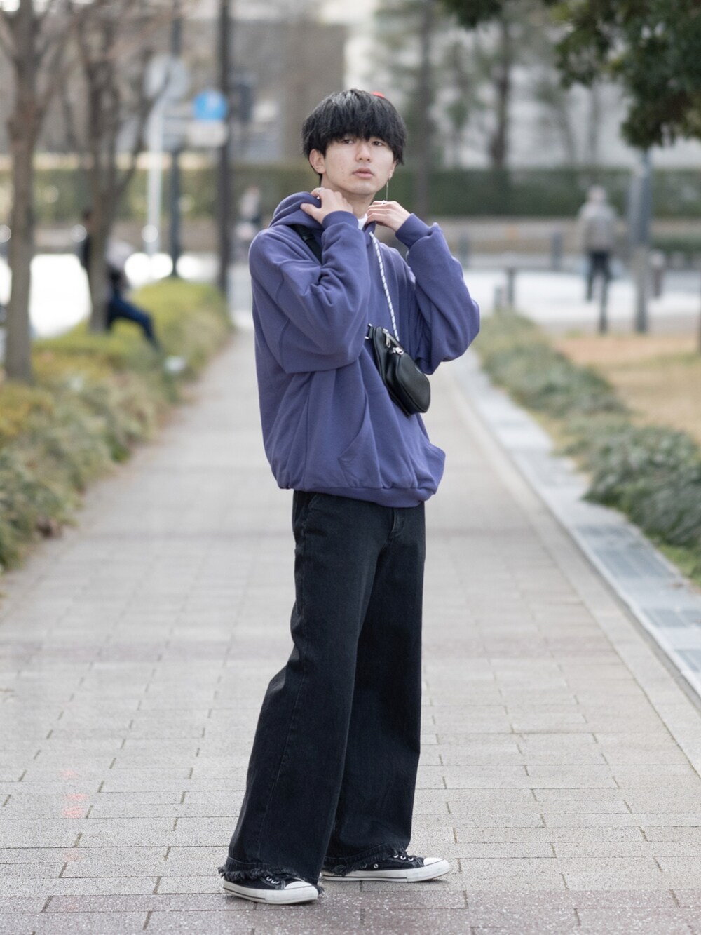 パープル系のパーカー、ブラック系のボディバッグ/ウエストポーチ、ブラック系のデニムパンツを着用したメンズの冬コーディネートの3枚目の写真