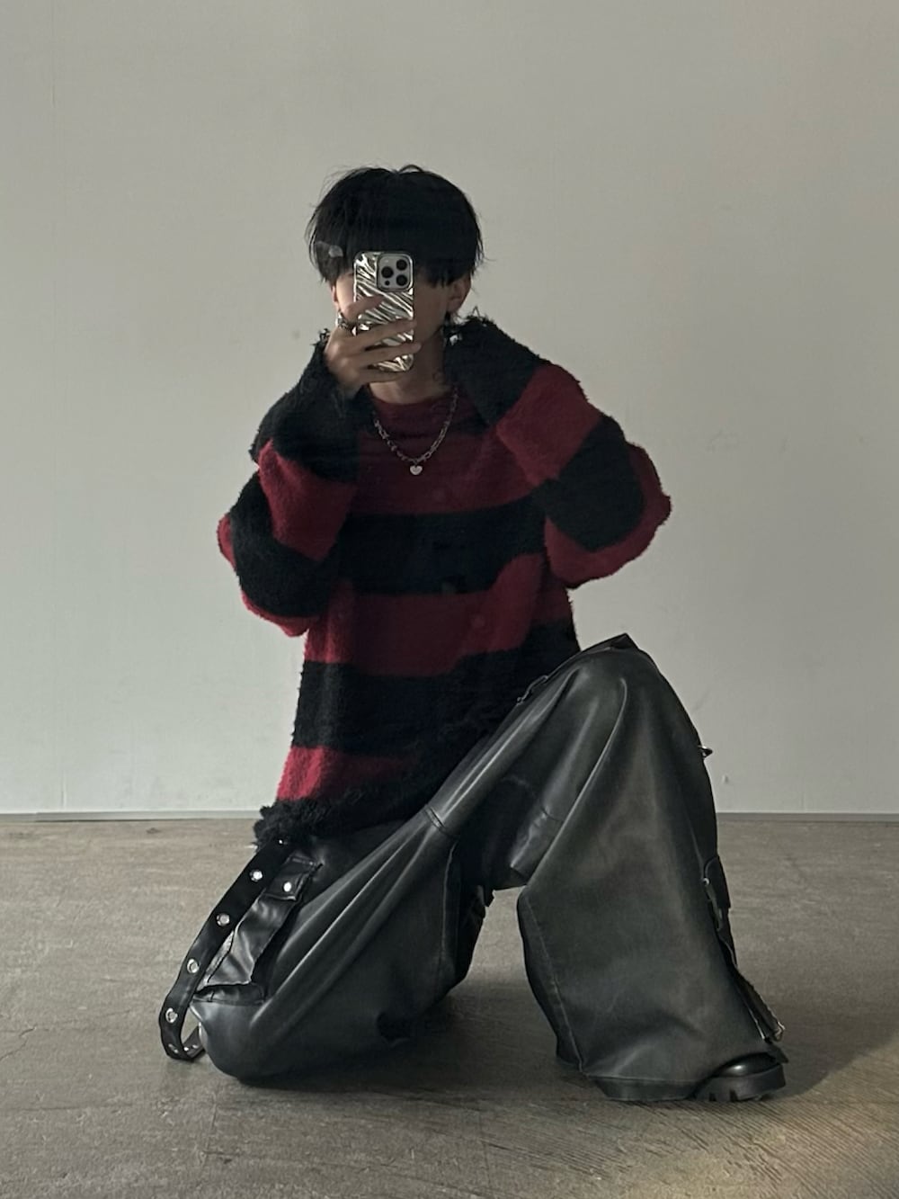 レッド系のニット/セーター、ブラック系のカーゴパンツを着用したメンズの秋コーディネートの2枚目の写真