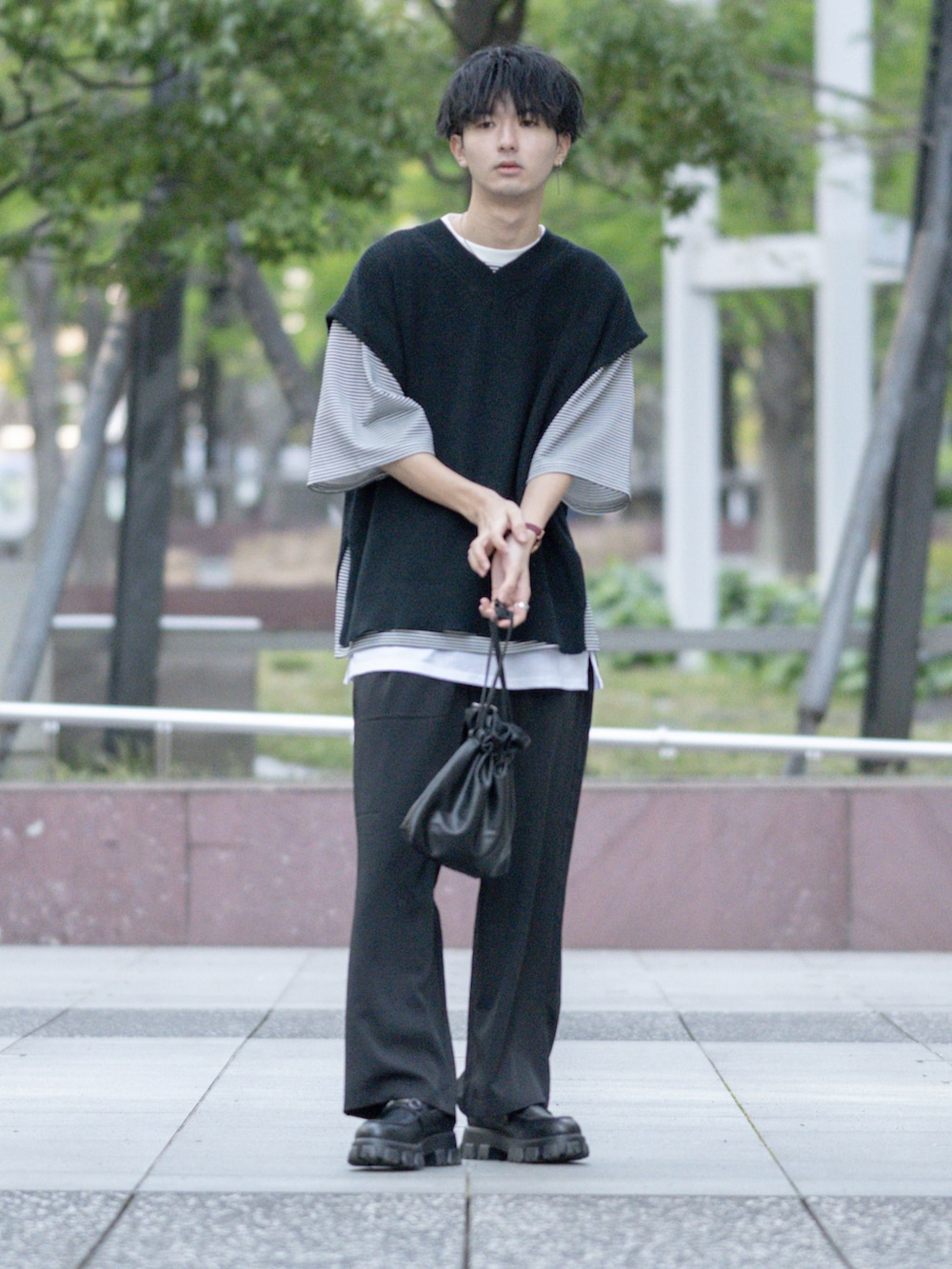 ブラック系のベスト、ホワイト系のTシャツ/カットソー、ブラック系のショルダーバッグを着用したメンズの夏コーディネートの2枚目の写真