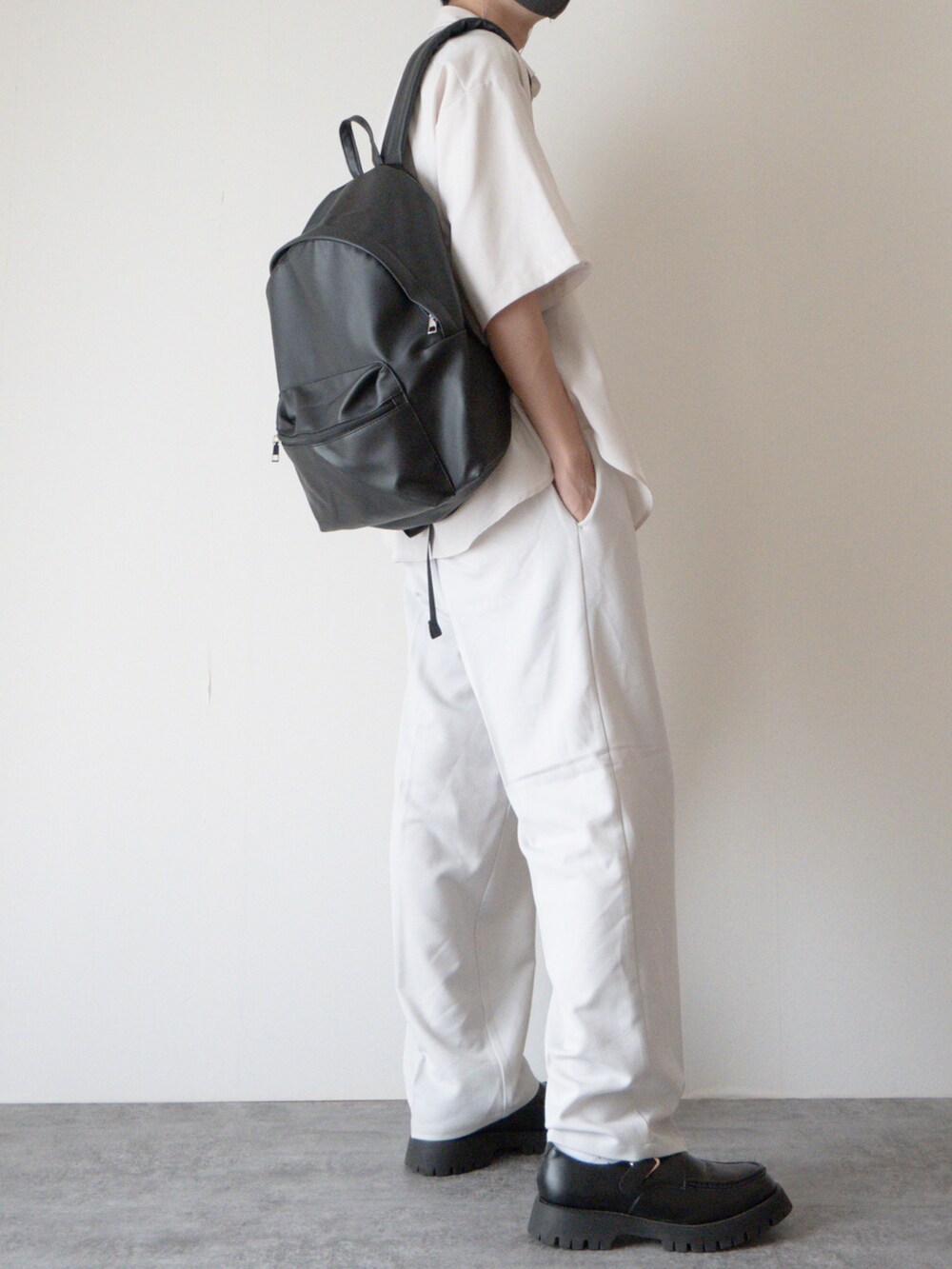 ホワイト系のシャツ/ブラウス、ブラック系のバックパック/リュック、グレー系のスラックスを着用したメンズの夏コーディネートの2枚目の写真