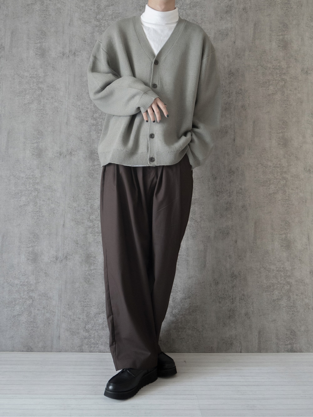 グレー系のカーディガン/ボレロ、ホワイト系のTシャツ/カットソー、ブラウン系のスラックスを着用したメンズの冬コーディネートの3枚目の写真