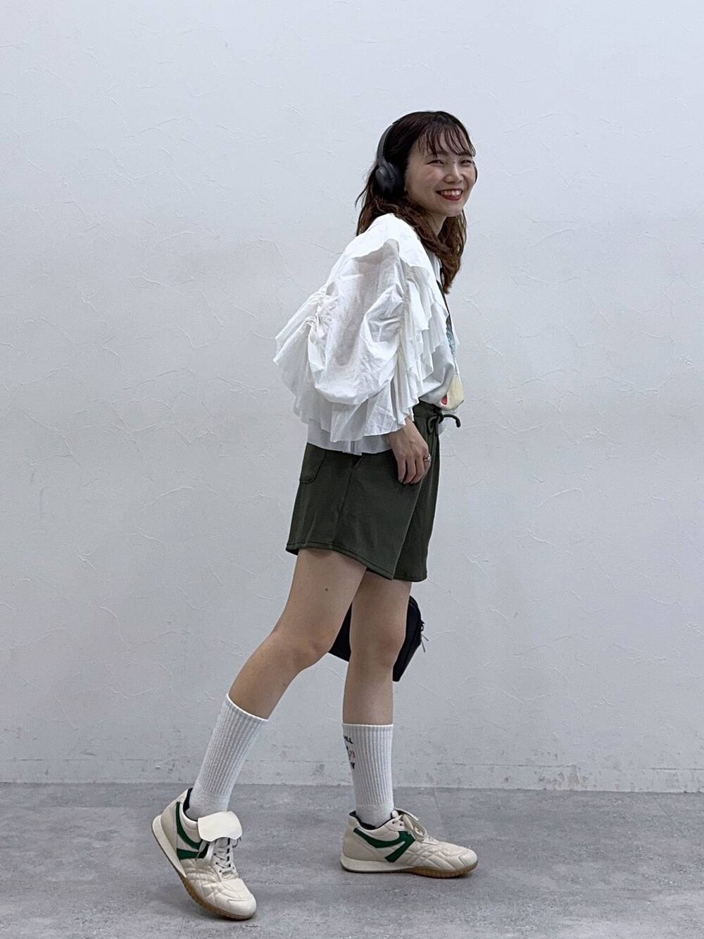 ホワイト系のTシャツ/カットソー、ベージュ系のスニーカー、ブラック系のボストンバッグを着用したレディースの夏コーディネートの2枚目の写真