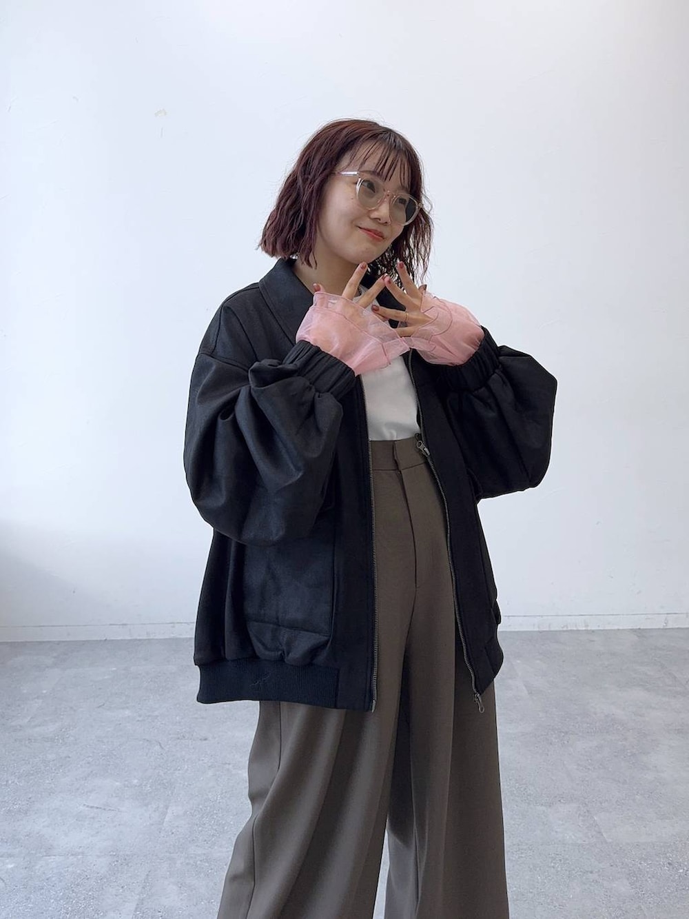 ブラック系のブルゾン、ブラウン系のスラックスを着用したレディースの秋コーディネートの5枚目の写真