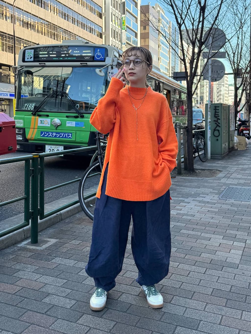 オレンジ系のニット/セーターを着用したレディースの冬コーディネートの2枚目の写真