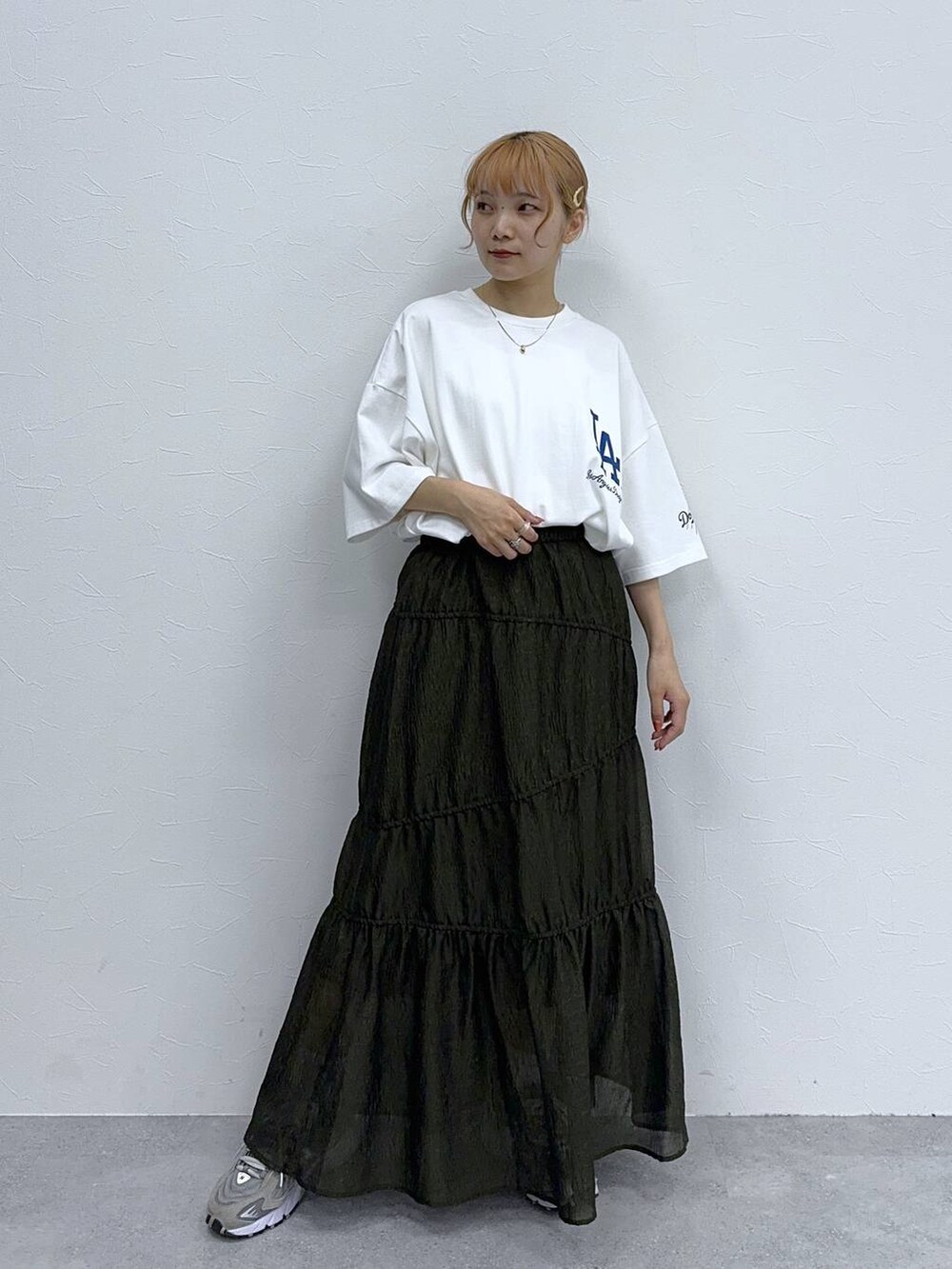 グリーン系のスカート、ホワイト系のTシャツ/カットソーを着用したレディースの夏コーディネートの3枚目の写真