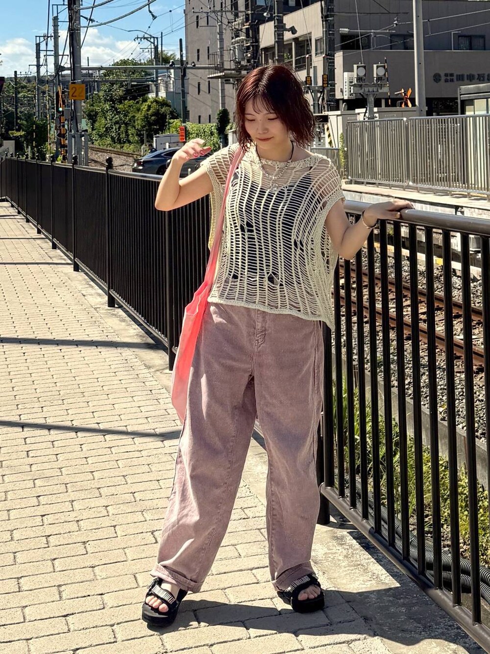 ベージュ系のベスト、ピンク系のデニムパンツを着用したレディースの夏コーディネートの2枚目の写真