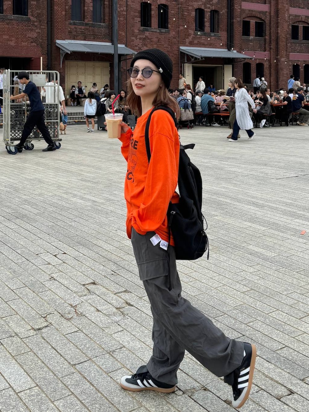 ブラック系のバックパック/リュック、グレー系のカーゴパンツを着用したレディースの秋コーディネートの2枚目の写真