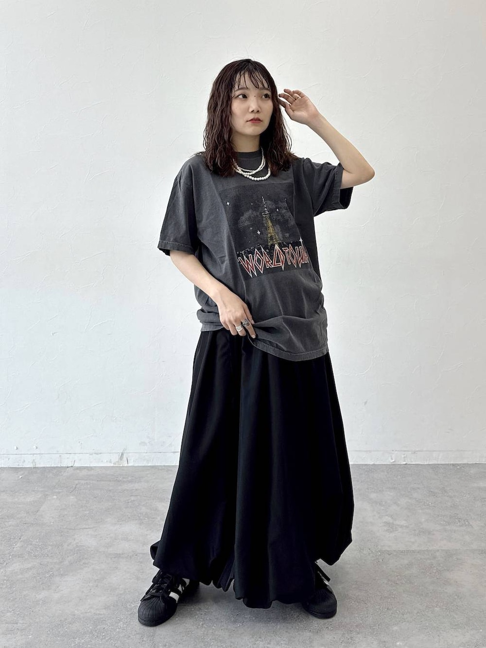 ブラック系のスカートを着用したレディースの夏コーディネートの2枚目の写真