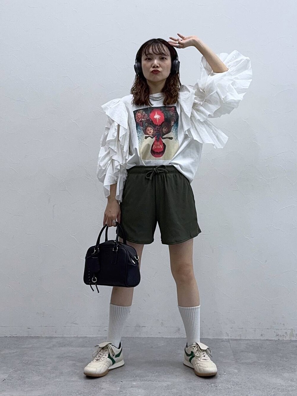 ホワイト系のTシャツ/カットソー、ベージュ系のスニーカー、ブラック系のボストンバッグを着用したレディースの夏コーディネートの3枚目の写真