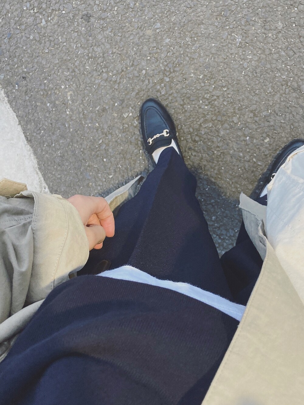 ベージュ系のステンカラーコート、ブルー系のスウェット、ホワイト系のTシャツ/カットソーを着用したレディースの秋コーディネートの2枚目の写真