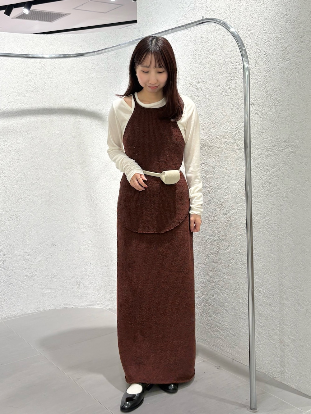 ブラウン系のスカート、ブラック系のローファー、ホワイト系のTシャツ/カットソーを着用したレディースの春コーディネートの2枚目の写真