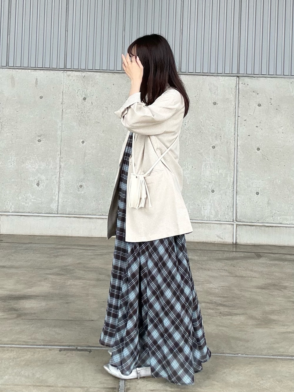 ブラウン系のワンピース、ベージュ系のその他アウター、ベージュ系のタンクトップを着用したレディースの春コーディネートの3枚目の写真