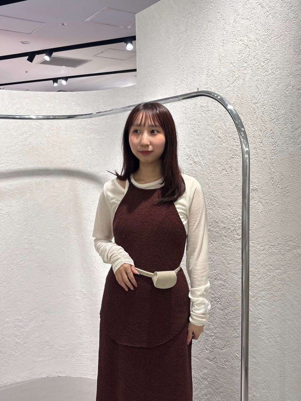 ブラウン系のスカート、ブラック系のローファー、ホワイト系のTシャツ/カットソーを着用したレディースの春コーディネートの6枚目の写真