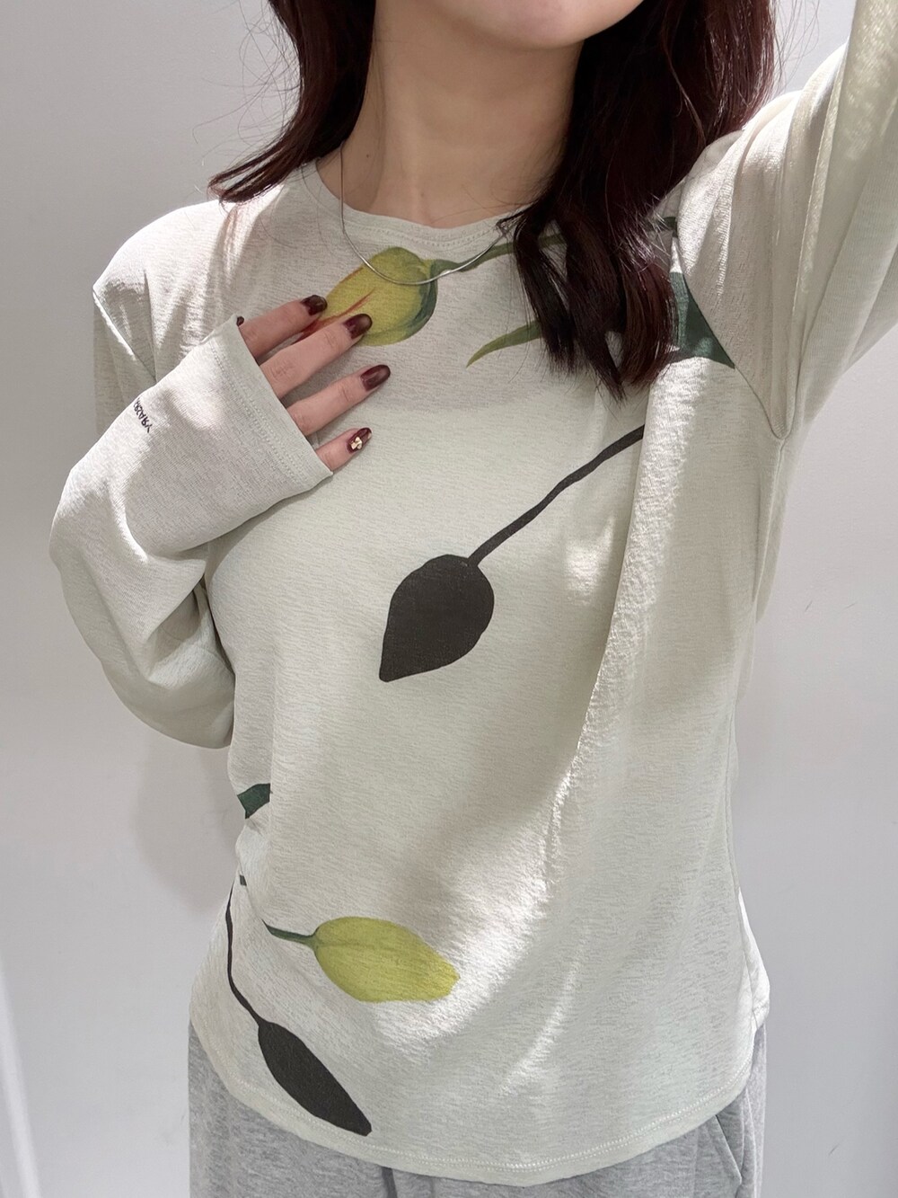 グリーン系のTシャツ/カットソー、ブラック系のボストンバッグ、ブラック系のスニーカーを着用したレディースの冬コーディネートの4枚目の写真