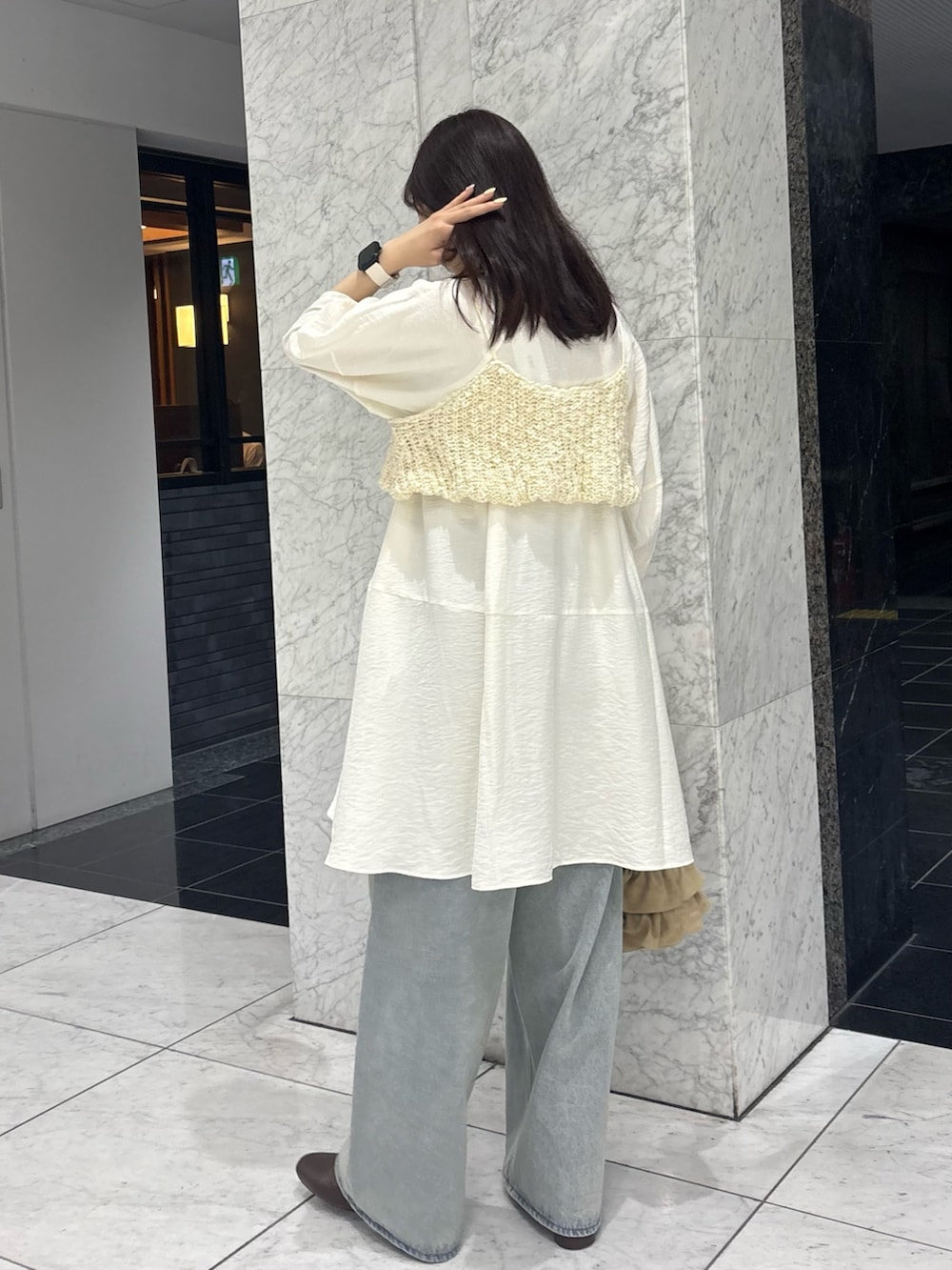 ホワイト系のワンピース、ホワイト系のニット/セーター、ブルー系のデニムパンツを着用したレディースの春コーディネートの4枚目の写真