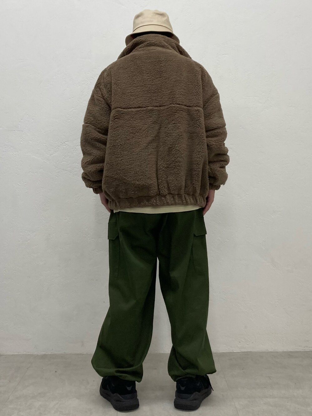グリーン系のカーゴパンツ、ブラック系のスニーカー、ブラウン系のブルゾンを着用したメンズの秋コーディネートの3枚目の写真