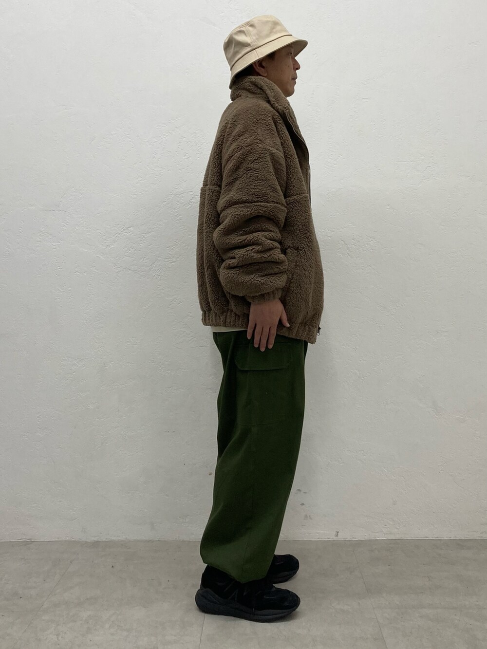 グリーン系のカーゴパンツ、ブラック系のスニーカー、ブラウン系のブルゾンを着用したメンズの秋コーディネートの2枚目の写真