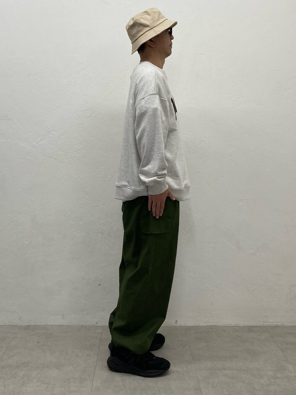 グリーン系のカーゴパンツ、ホワイト系のスウェットを着用したメンズの秋コーディネートの3枚目の写真