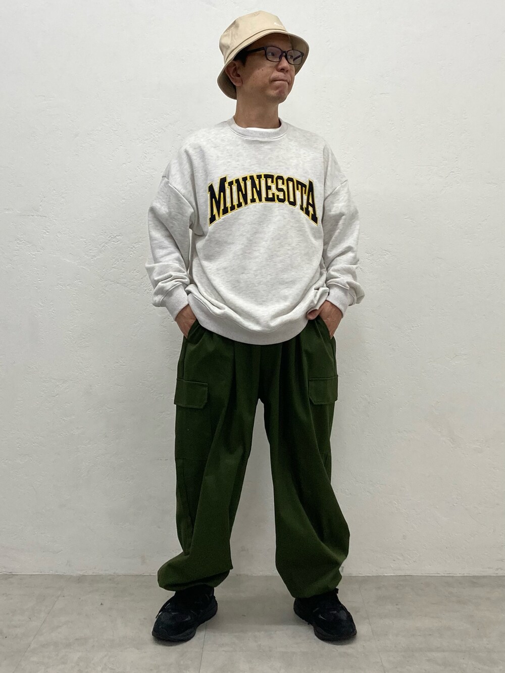 グリーン系のカーゴパンツ、ホワイト系のスウェットを着用したメンズの秋コーディネートの2枚目の写真