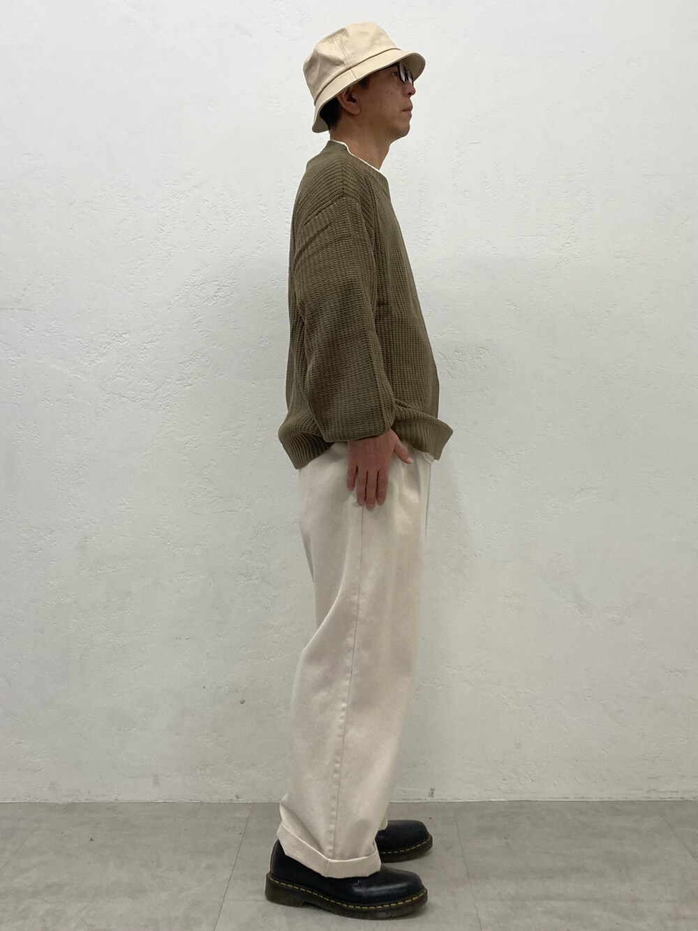ホワイト系のデニムパンツ、ブラウン系のニット/セーターを着用したメンズの秋コーディネートの2枚目の写真