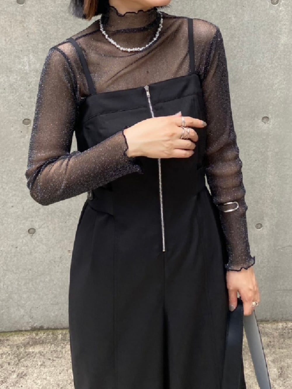 ブラック系のショルダーバッグ、ブラック系のTシャツ/カットソー、ブラック系のサロペット/オーバーオールを着用したレディースの春コーディネートの2枚目の写真