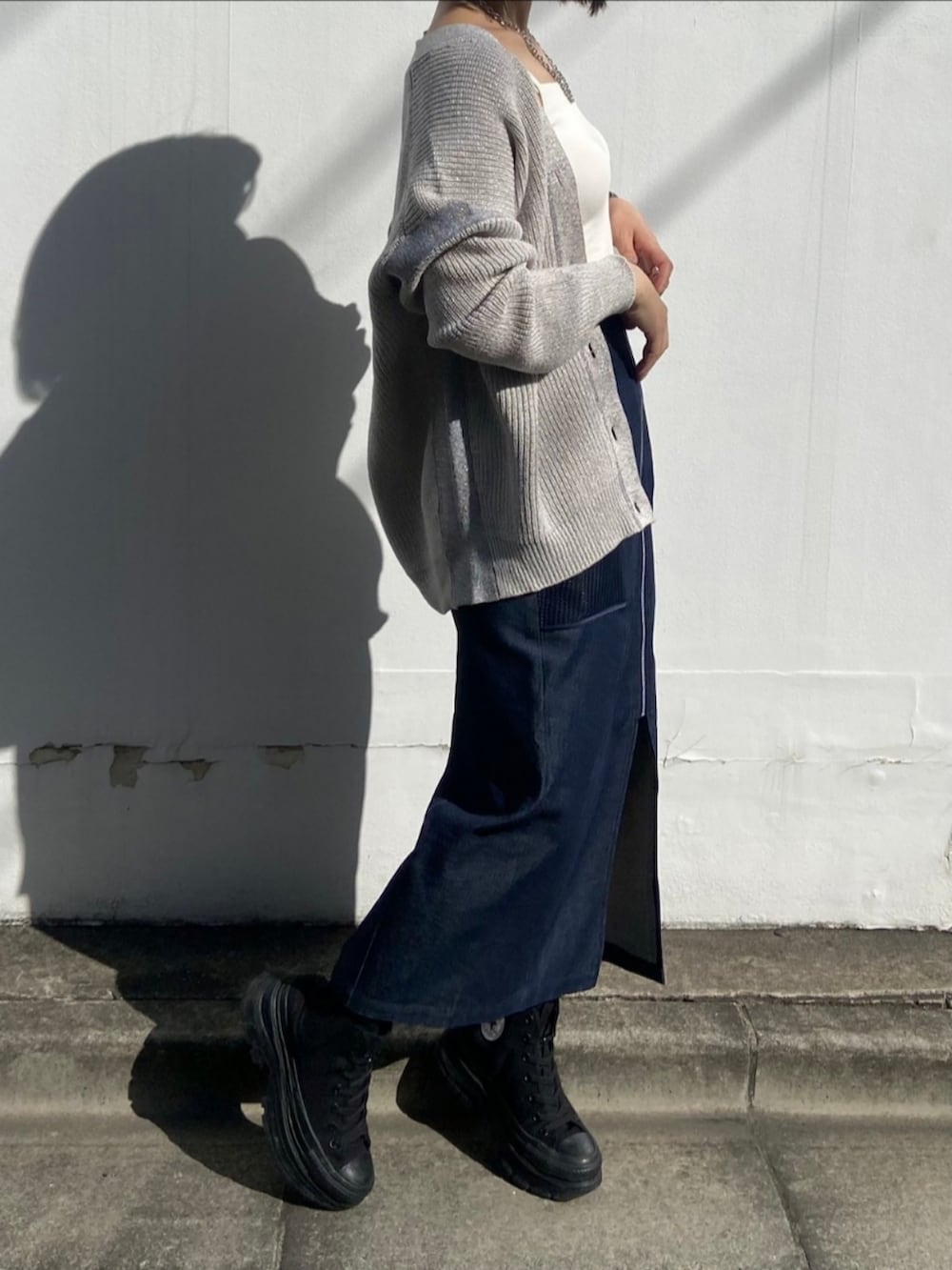 ブラック系のスニーカー、ベージュ系のカーディガン/ボレロ、ブルー系のスカートを着用したレディースの春コーディネートの2枚目の写真