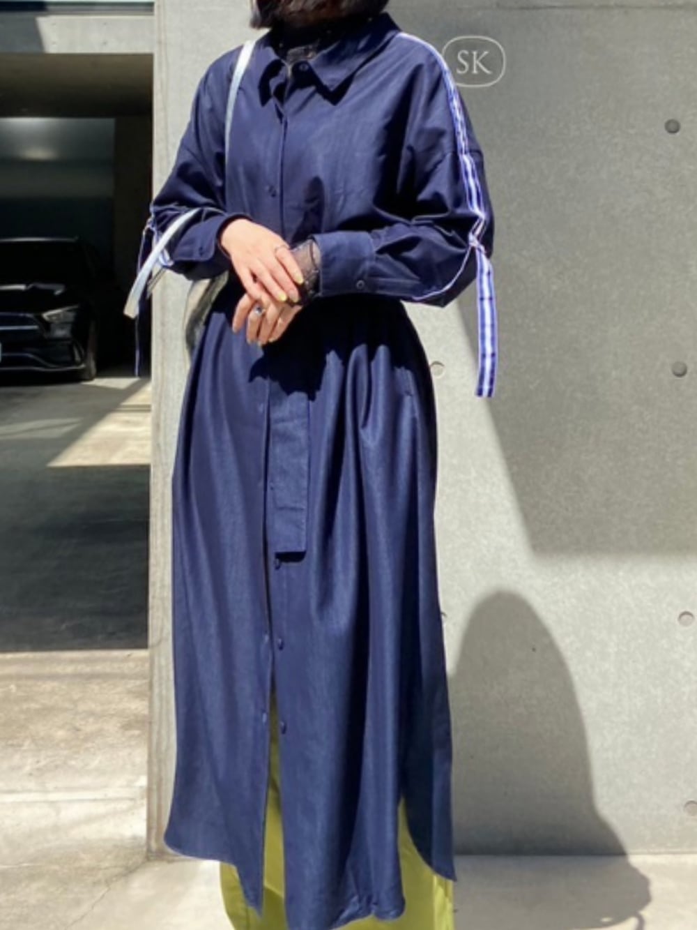 ブラック系のスニーカー、ブルー系のシャツワンピース、イエロー系のその他パンツを着用したレディースの春コーディネートの2枚目の写真