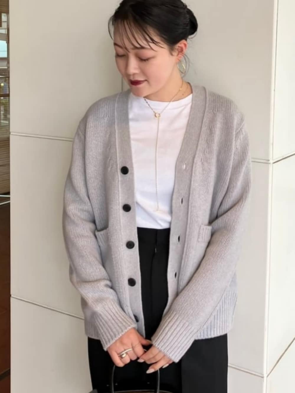 ブラック系のその他パンツ、ブラック系のトートバッグ、グレー系のカーディガン/ボレロを着用したレディースの秋コーディネートの2枚目の写真