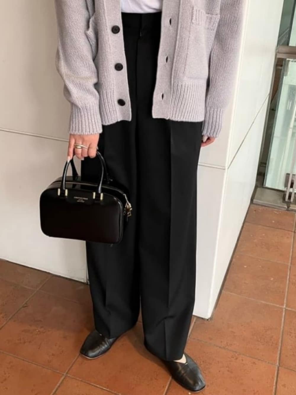 ブラック系のその他パンツ、ブラック系のトートバッグ、グレー系のカーディガン/ボレロを着用したレディースの秋コーディネートの3枚目の写真