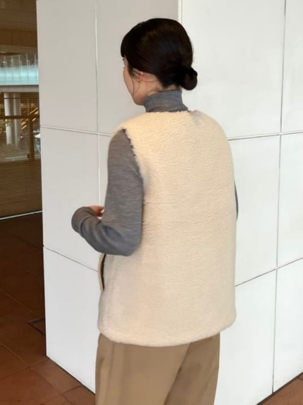 ブラウン系のニット/セーター、ベージュ系のその他パンツ、ホワイト系のその他アウターを着用したレディースの秋コーディネートの5枚目の写真