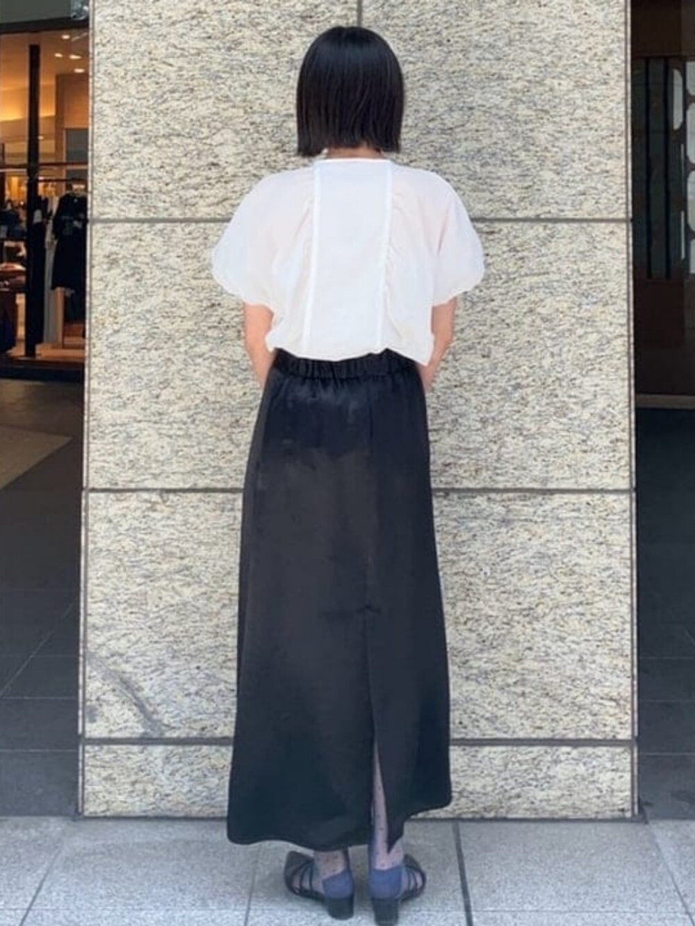 ホワイト系のシャツ/ブラウス、ブラック系のスカートを着用したレディースの夏コーディネートの2枚目の写真
