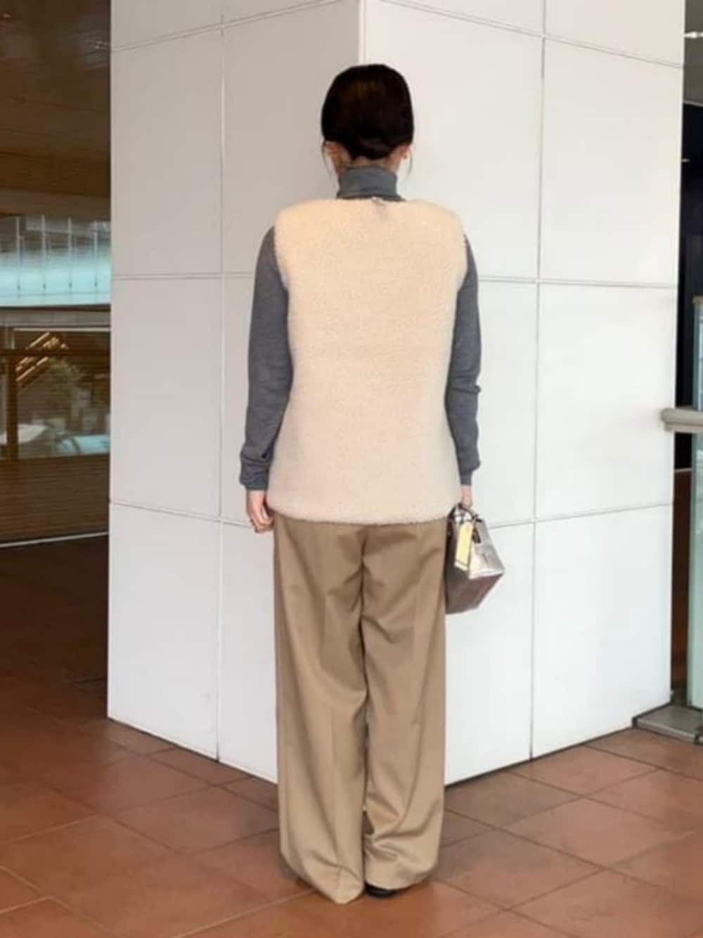 ブラウン系のニット/セーター、ベージュ系のその他パンツ、ホワイト系のその他アウターを着用したレディースの秋コーディネートの3枚目の写真