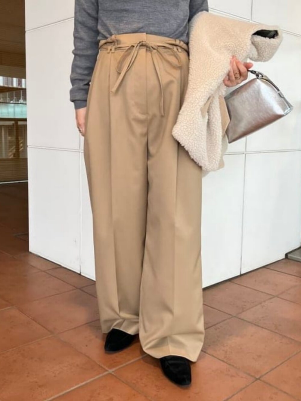 ブラウン系のニット/セーター、ベージュ系のその他パンツ、ホワイト系のその他アウターを着用したレディースの秋コーディネートの7枚目の写真