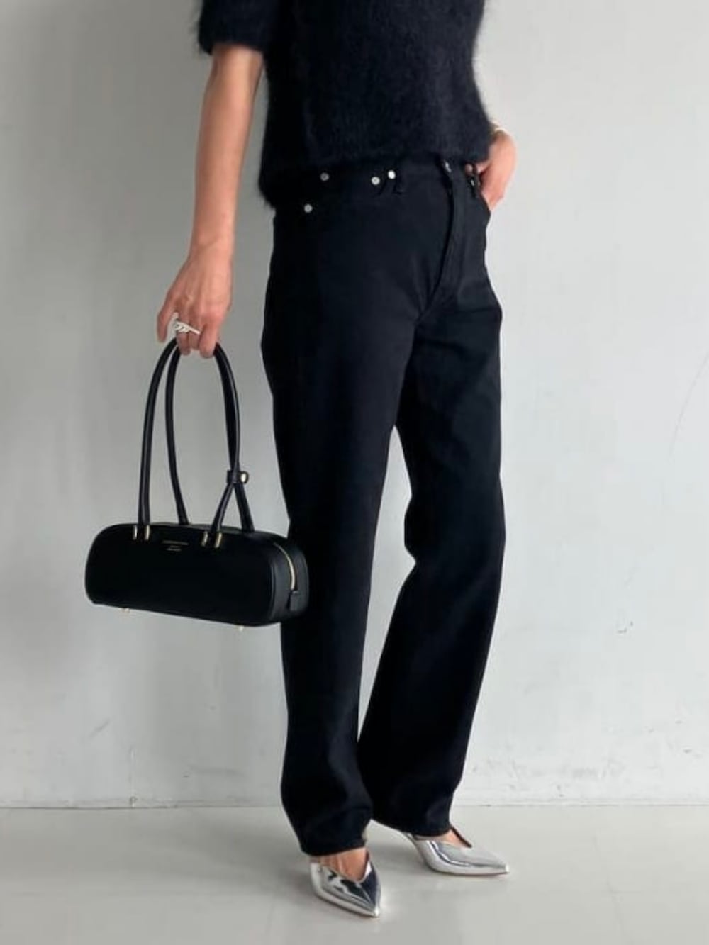 ブラック系のデニムパンツを着用したレディースの秋コーディネートの2枚目の写真