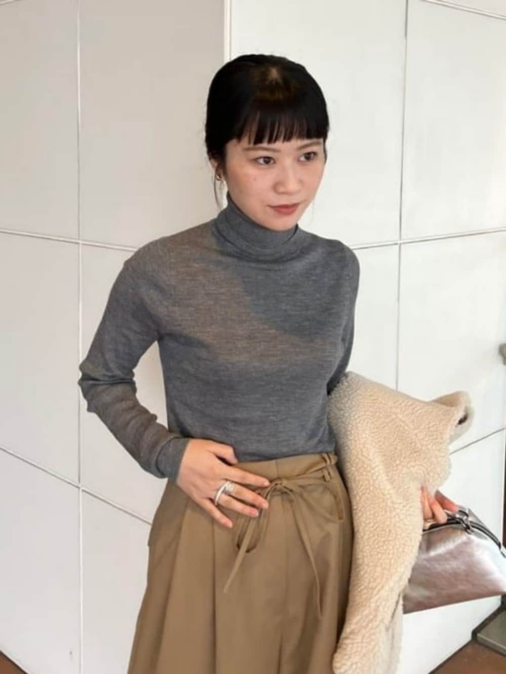 ブラウン系のニット/セーター、ベージュ系のその他パンツ、ホワイト系のその他アウターを着用したレディースの秋コーディネートの6枚目の写真