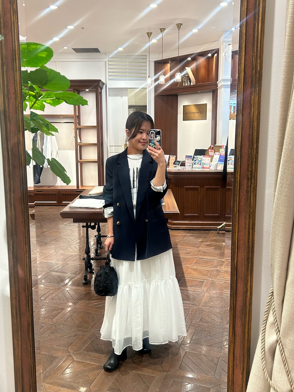 ブルー系のテーラードジャケット、ホワイト系のTシャツ/カットソー、ホワイト系のスカートを着用したレディースの冬コーディネートの2枚目の写真