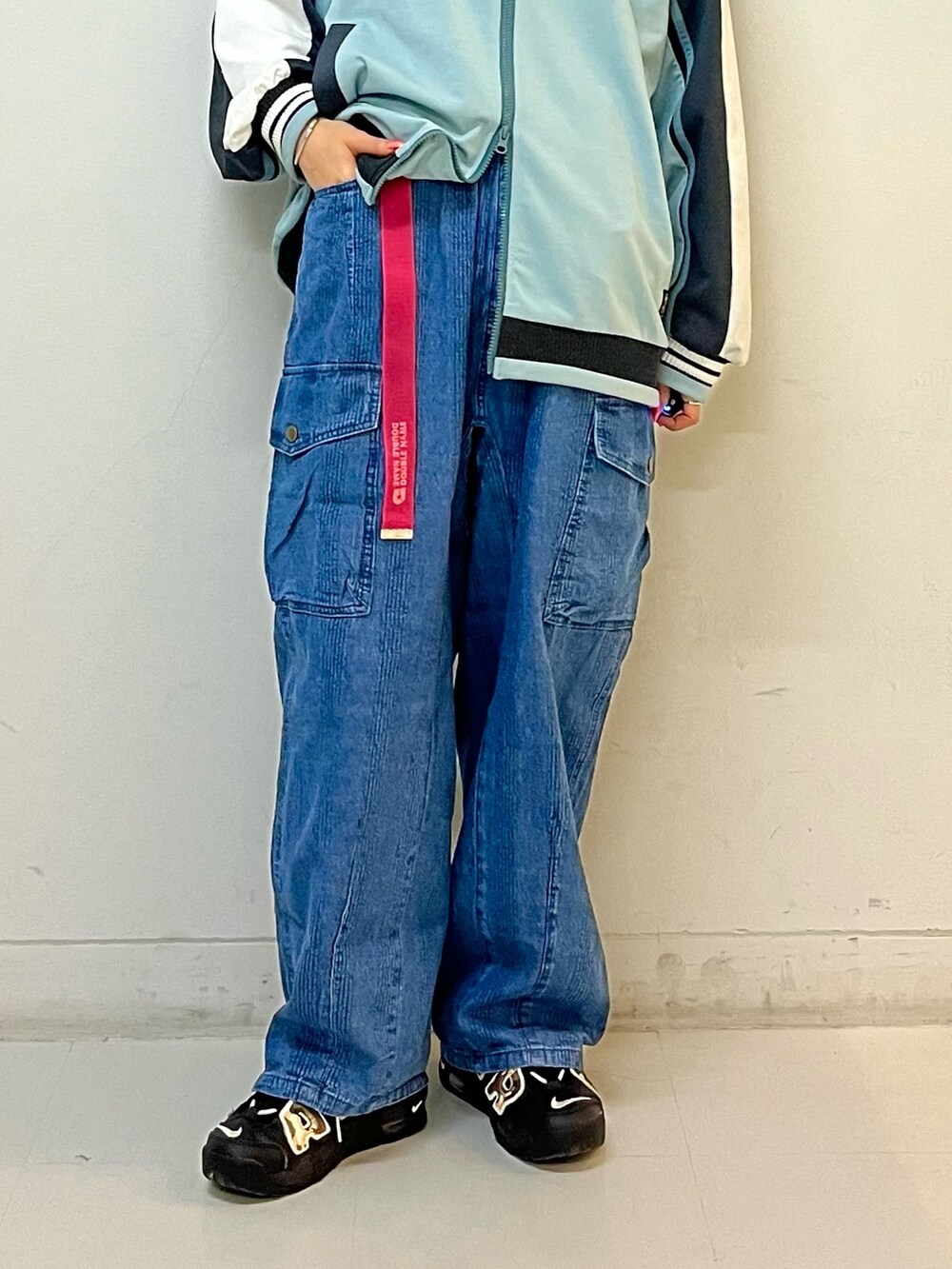 ブルー系のジャージ、ブルー系のデニムパンツ、ピンク系のベルトを着用したレディースの春コーディネートの6枚目の写真