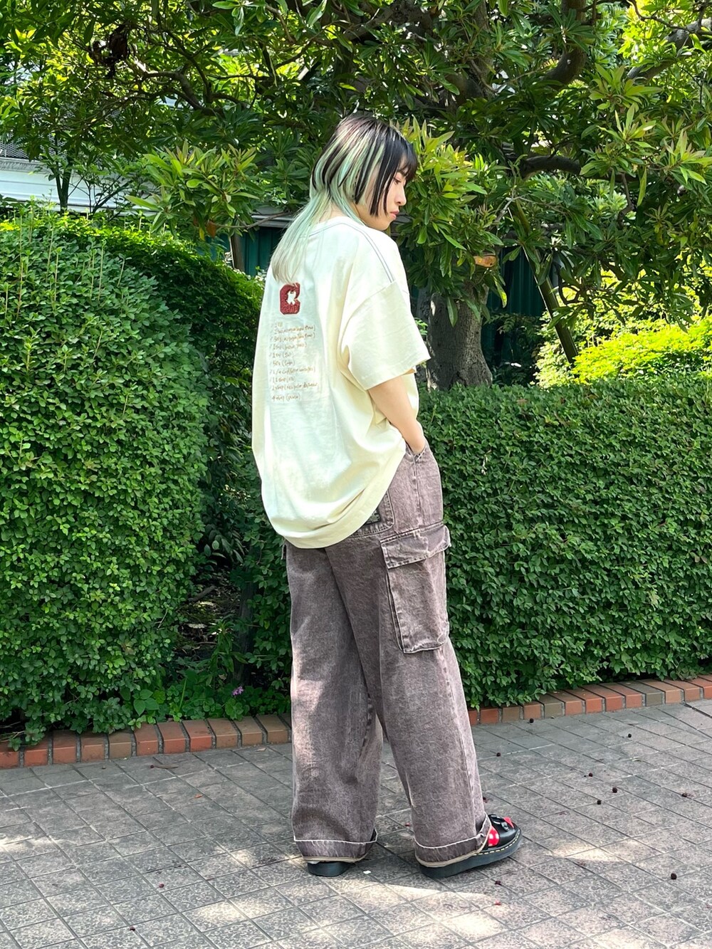 ホワイト系のTシャツ/カットソー、ブラウン系のデニムパンツ、ブラック系のベルトを着用したレディースの夏コーディネートの2枚目の写真