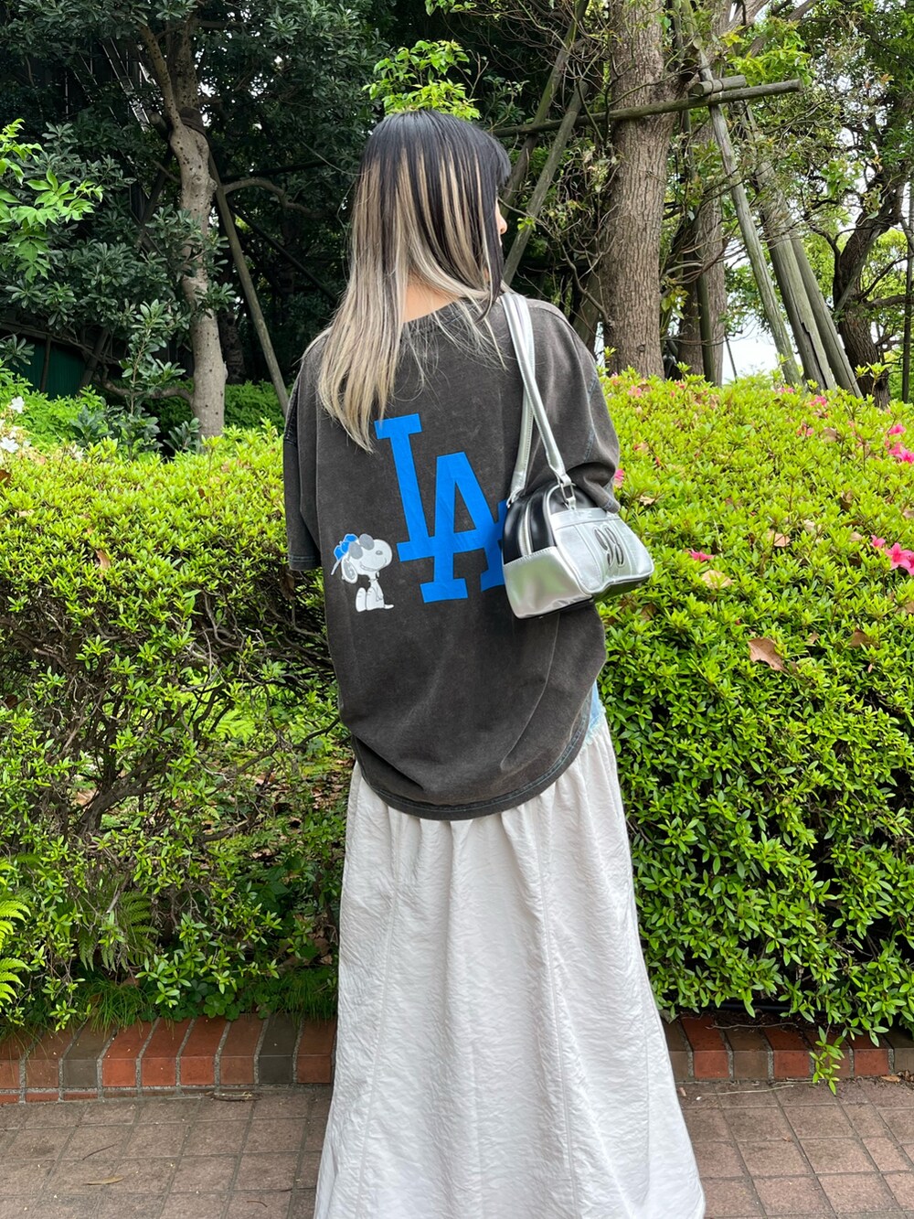 ホワイト系のスカート、ブラック系のTシャツ/カットソー、シルバー系のハンドバッグを着用したレディースの夏コーディネートの4枚目の写真