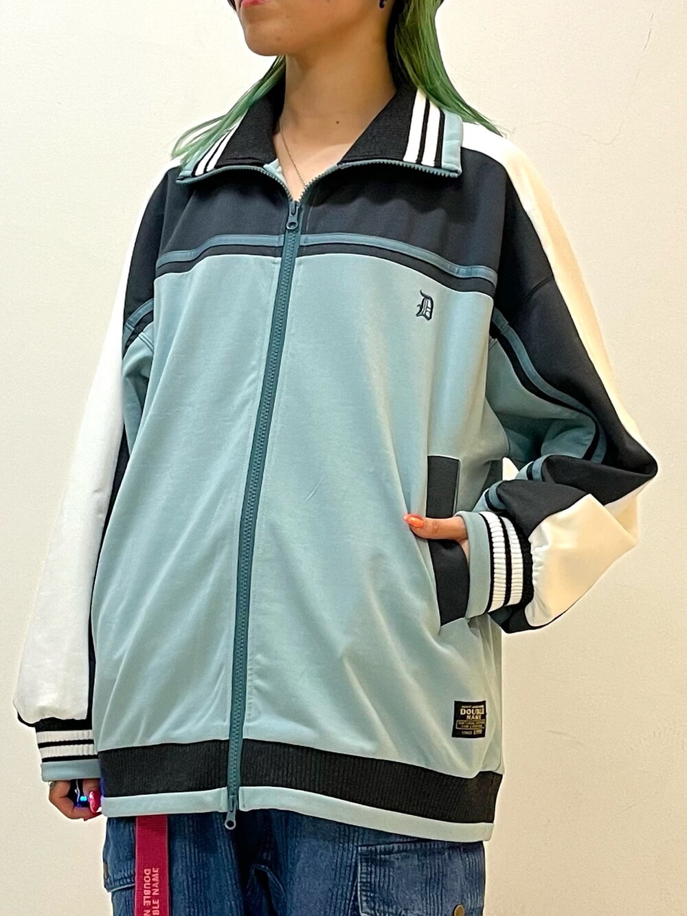 ブルー系のジャージ、ブルー系のデニムパンツ、ピンク系のベルトを着用したレディースの春コーディネートの5枚目の写真