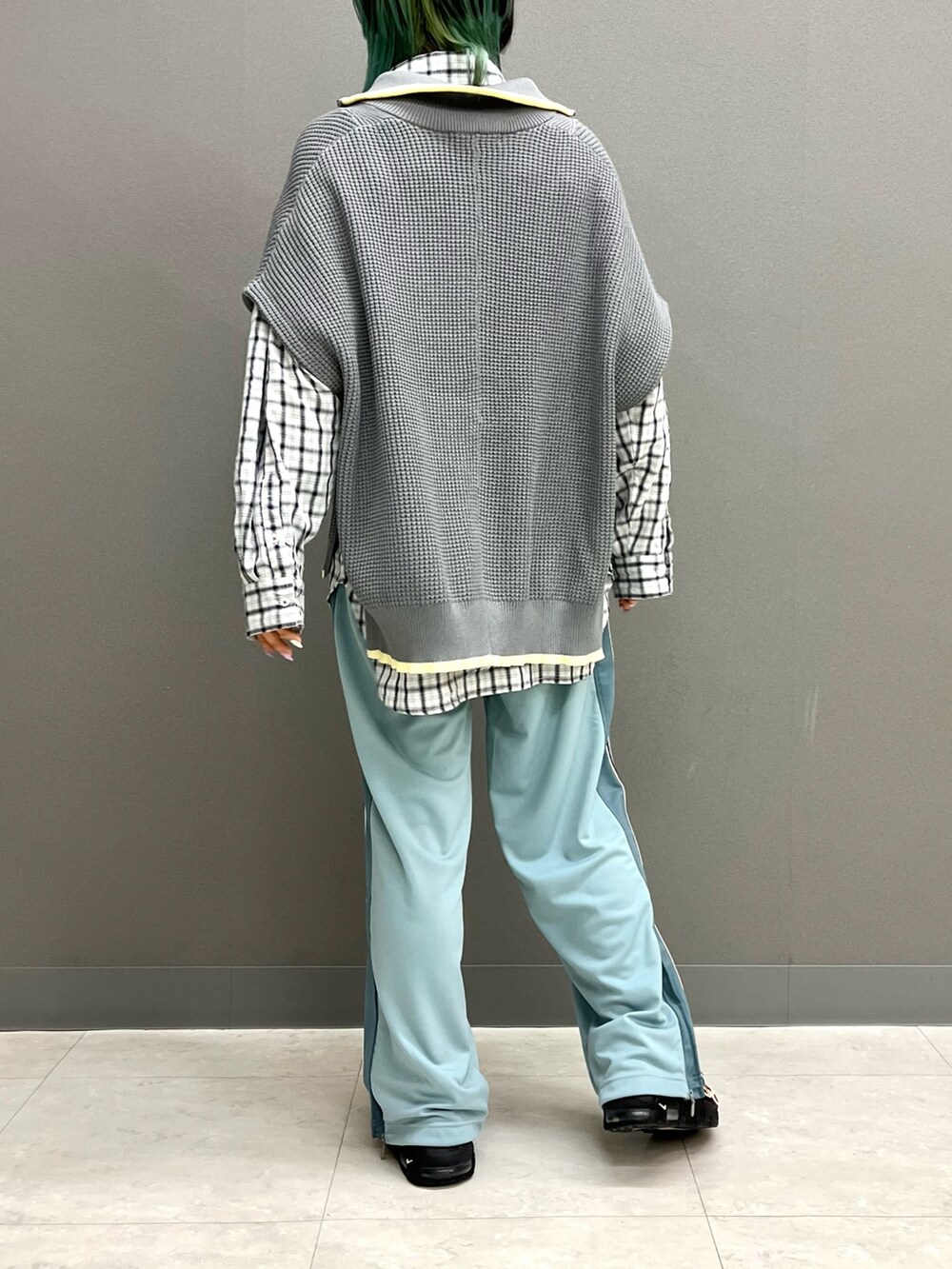 グレー系のニット/セーター、ホワイト系のシャツ/ブラウス、ブルー系のその他パンツを着用したレディースの春コーディネートの4枚目の写真