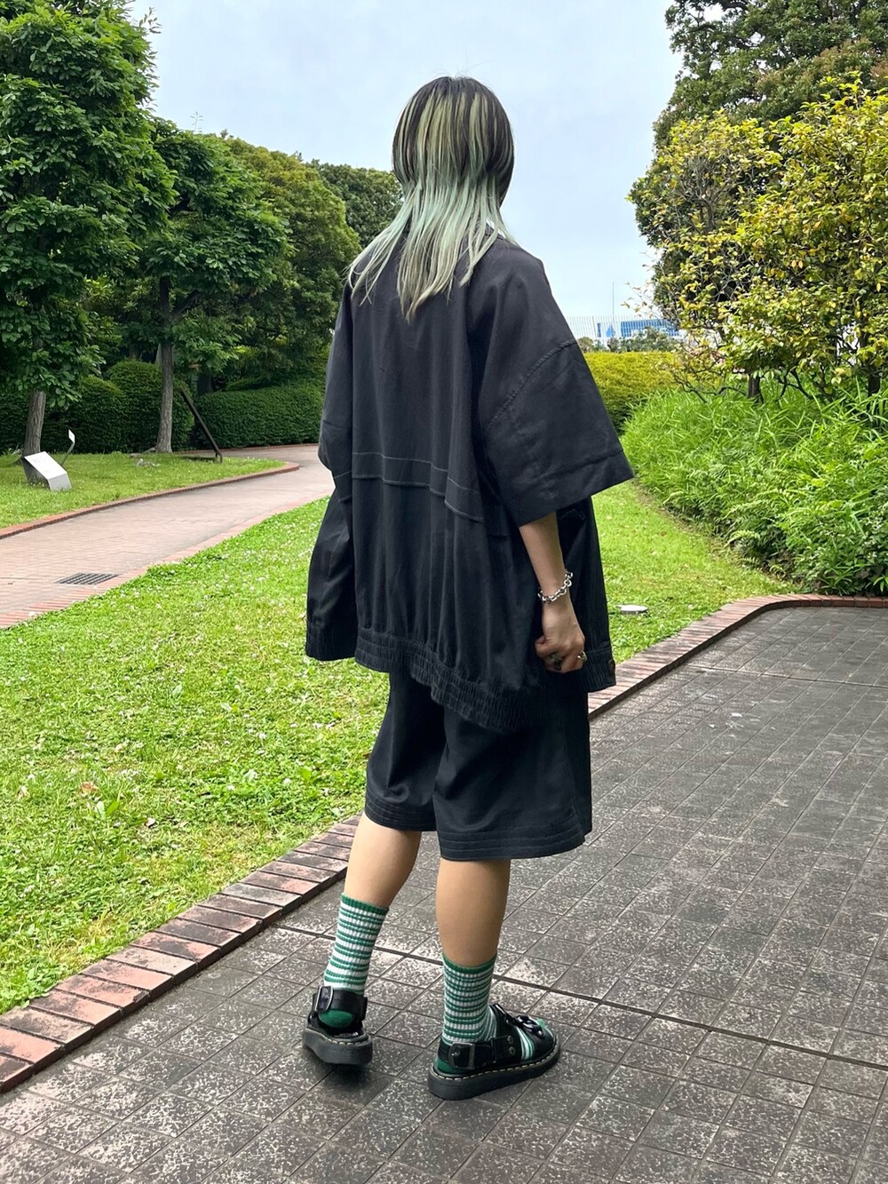 ブラック系のその他パンツ、ブラック系のその他アウター、ベージュ系のTシャツ/カットソーを着用したレディースの春コーディネートの2枚目の写真