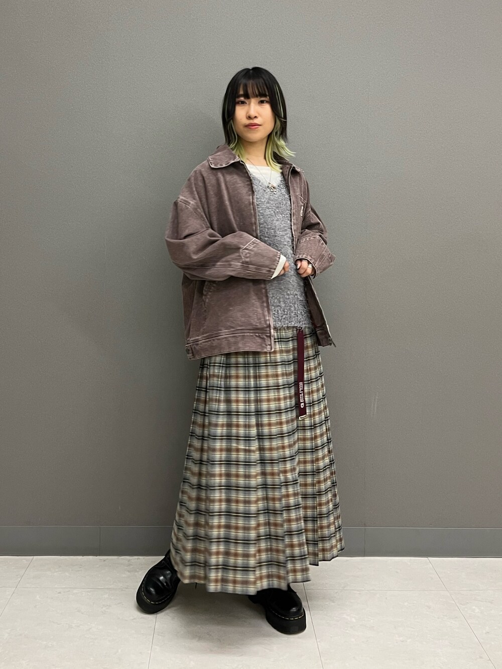 ブラウン系のブルゾン、ホワイト系のTシャツ/カットソー、グレー系のベストを着用したレディースの秋コーディネートの2枚目の写真